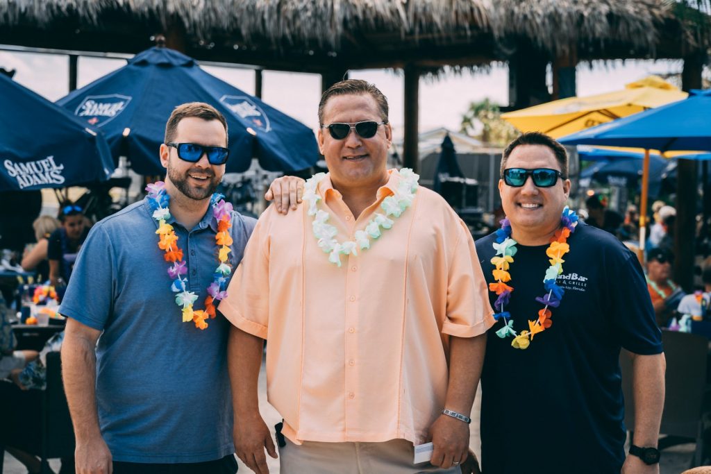 three men in leis and sunglasses