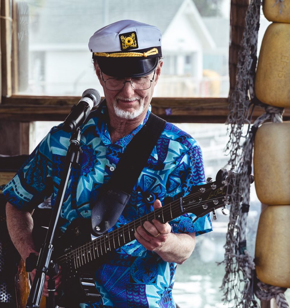 man in a captains hat playing guitar